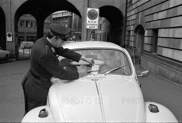 Policeman distributes monetary fines, Zurich 1970