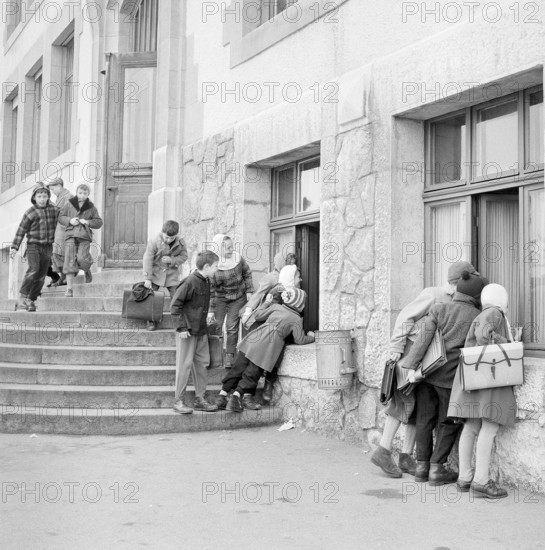 Peseux, nosy children looking through the window to elder pupils attending a cookery course, 1958