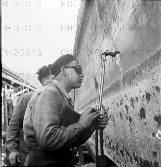 Preparation of overland ship transpor, cutting hull in two with blowtorch, 1946