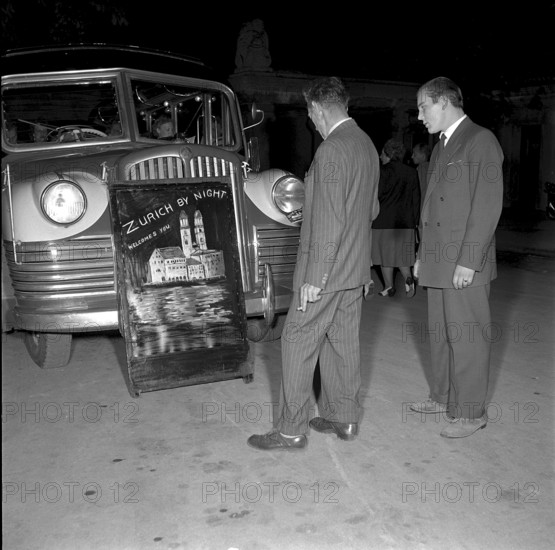 Zurich by night 1952: two men in front of a poster ""Zurich by Night