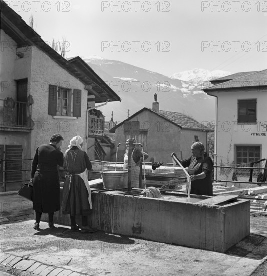 Sierre, women doing their laundry at the fountain, 1941