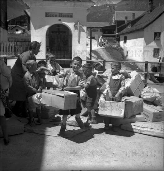Children carrying parcels, relief supplies for the population of the completely burned down hamlet Selva 1949