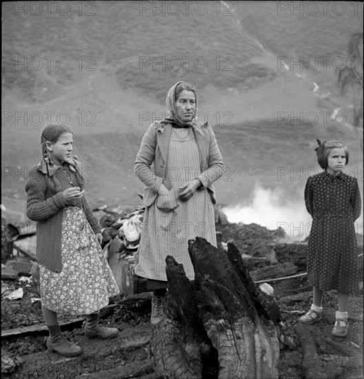 Selva completely burned down, woman and girl watching the remains of their household 1949