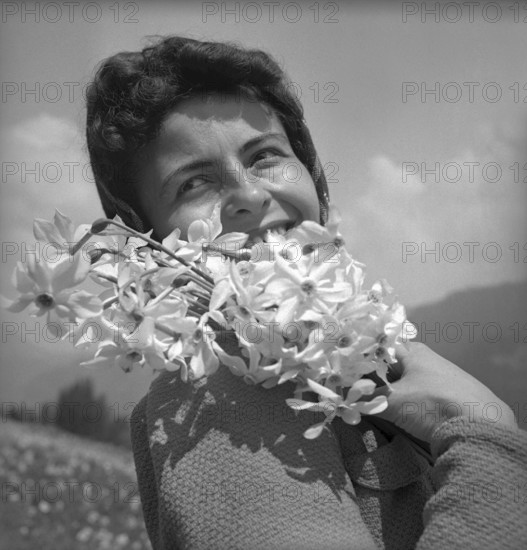 Woman posing with wild narcissus in Vevey, 1942