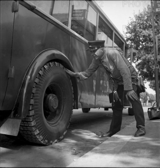 Bus driver checking chains for tyre protection, Berne 1945