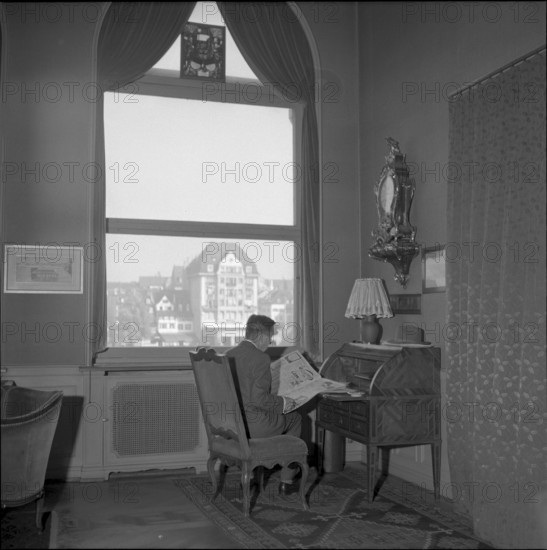 Basle, Man resident in the Hotel drei Konige reading a newspaper, 1954