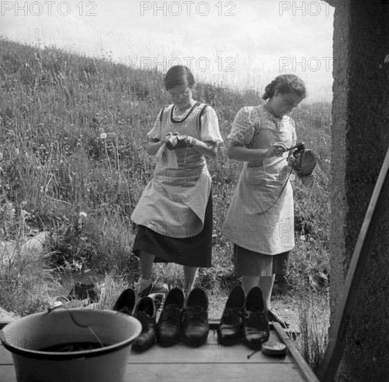 Cleaning shoes at school for household in Casoja, 1940