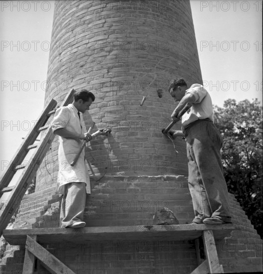 Explosive charge attachment before factory chimney blasting in Geneva 1943