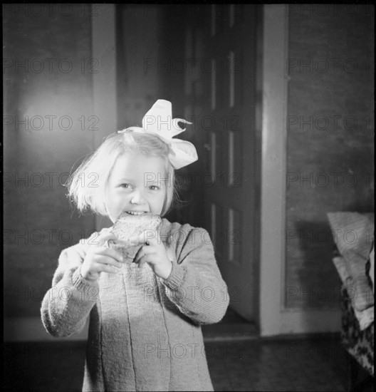 Girl eats piece of bread, approx. 1950
