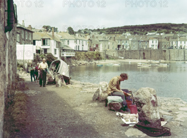People on coastal path at seaside village of Mousehole.