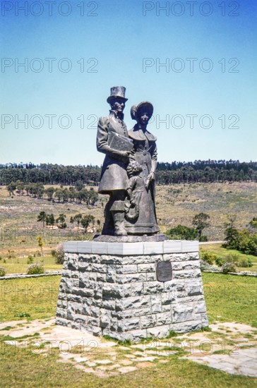 bronze statue of a Victorian-era settler family (a man, woman, and child) at the 1820 Settlers National Monument in Grahamstown (now Makhanda), South Africa.