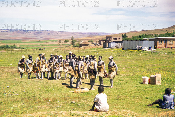 Basotho women dancers in traditional attire practice a performance in a rural area.