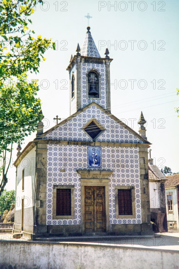 This building is the Capela de Sv£o Jov£o de Ovar (Chapel of St. John of Ovar), located in Ovar, Portugal. It is a traditional Portuguese chapel famous for its beautiful exterior facade covered in blue and white azulejo tiles