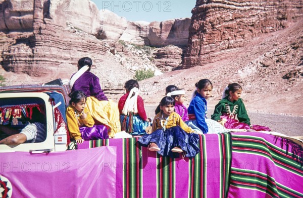 Dine Navajo children and families sitting on back of a truck.