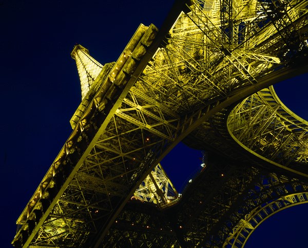 FRANCE, Ile de France, Paris, Eiffel Tower. Angled view from below floodlit at night.