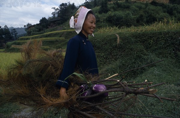 10000593 CHINA Guizhou Leishan Woman carying branches and vegetation and aubergines.