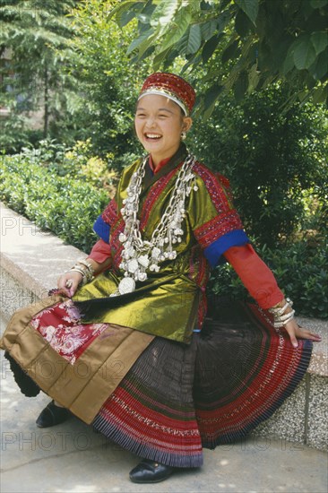 CHINA, Guizhou, Kiali, Seated Miao girl wearing festival dress