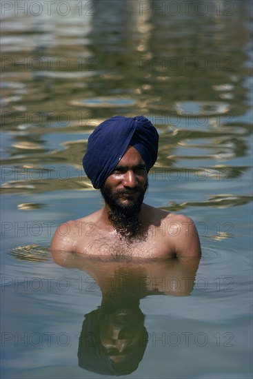 INDIA, Punjab, Amritsar, Hari Mandir or Golden Temple. Ritual bather in the Pool of Immortality to attain spiritual purification.