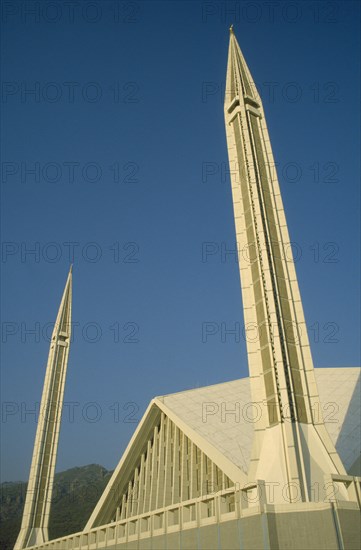PAKISTAN, Islamabad, "Faisal mosque.  Detail of white rooftop and minarets against blue sky.  Design by Vedat Dalokay, construction completed 1986."