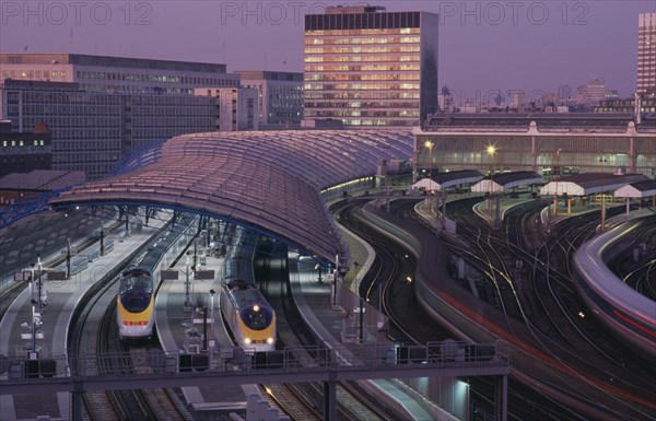 ENGLAND, London ,  Waterloo Station International Terminal with Eurostar trains in evening.  City buildings behind.