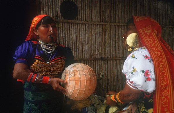 INDIA, San Blas Islands, Cuna Indian women washing clothes with one smoking a pipe