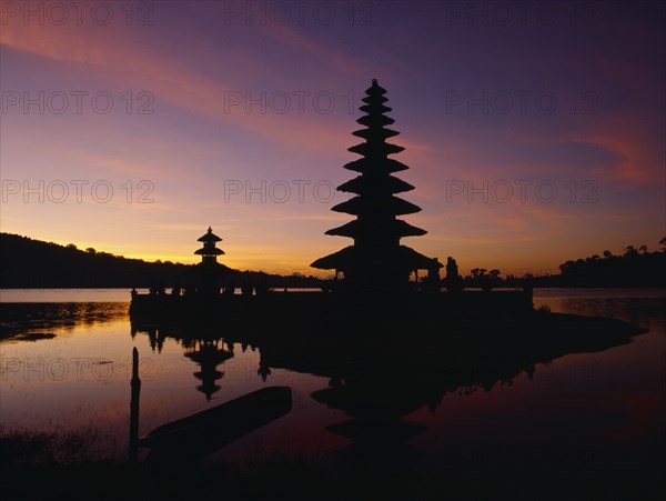 INDONESIA, Bali, Candikuning, View across Lake Bratan towards island temple of Pura Ulu Danau dedicated to Dewi Danau the goddess of the waters at sunset.