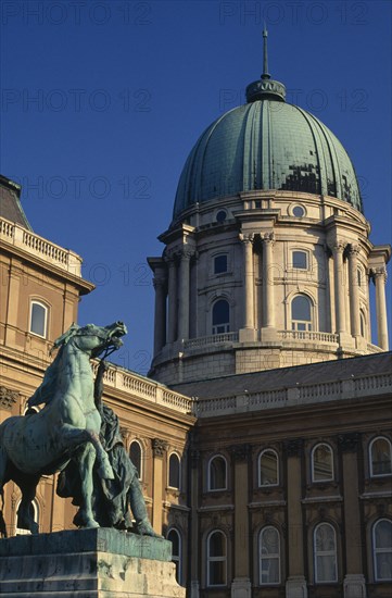 HUNGARY, Budapest, "The Royal Palace, part view of exterior and domed roof with statue of man restraining horse in the courtyard in foreground. "