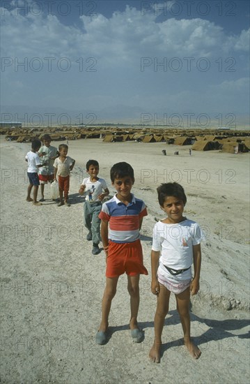 TURKEY, Sirnak, Silopi, Group of Kurdish refugee children at Haji Camp with rows of tents behind them