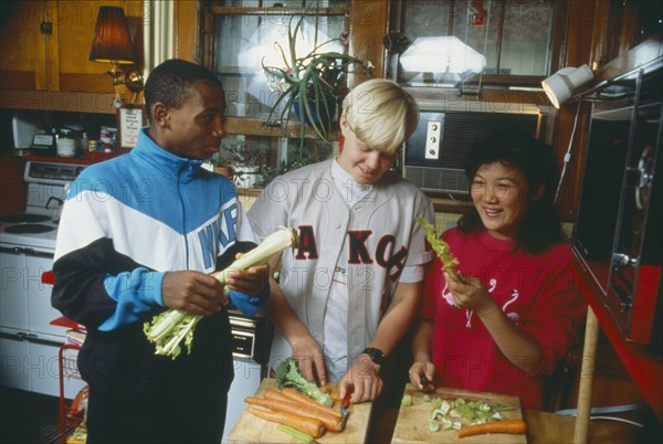 FOOD , Preparation, Teenagers making a salad in domestic kitchen.