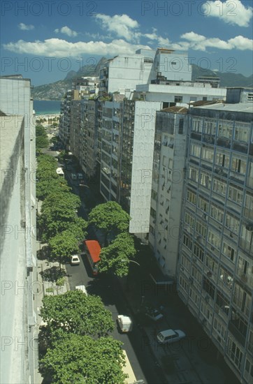 BRAZIL, Rio de Janeiro, "Aerial view along city street toward Ipanema and favela, or slum, on a hillside in the distance"