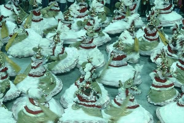 BRAZIL, Rio de Janeiro, Carnival dancers in red gold and white spinning around in procession