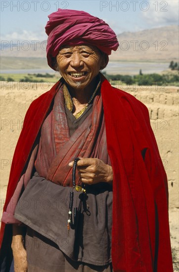 CHINA, Shandong Province, Near Guide, Tibetan Buddhist Monk by the Yellow River holding prayer beads