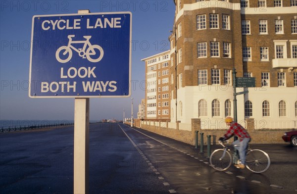 10012731 SPORT Cycling Cyclist on cycle lane on Hove seafront with sign in the foreground