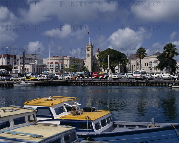 BARBADOS, Bridgetown, "The Carenage seen from across the sea  with buildings,church tower,cars, boats on water in foreground"