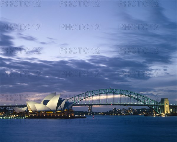 AUSTRALIA, New South Wales, Sydney, The Opera House and Harbour Bridge lit up at dusk