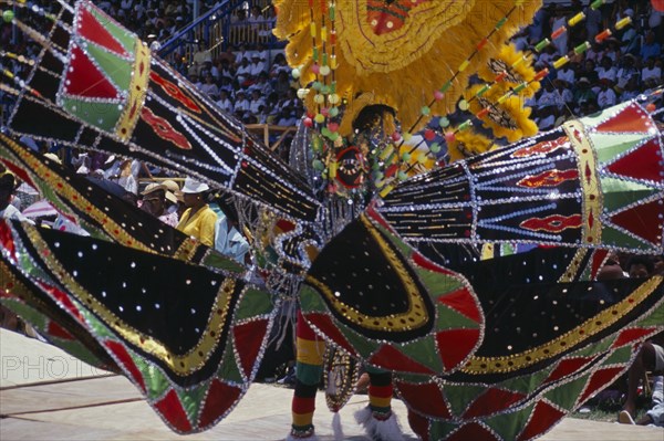 WEST INDIES, Barbados, Festivals, "Crop Over sugar cane harvest festival.  Grand Kadooment carnival parade performer in elaborate black, red, yellow and green masked costume."