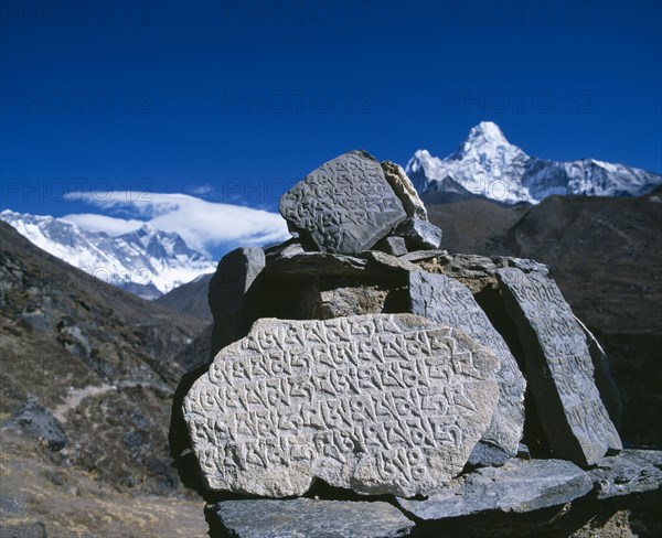 NEPAL, Sagarmatha National Park, Mount Everest, Mani stones in foreground with snow capped peak of Mount Everest behind.