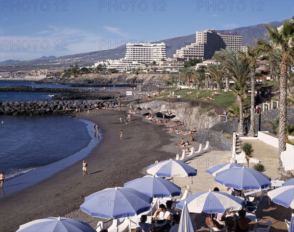 SPAIN, Canary Islands, Tenerife, Playa de la Americas with black sandy beach and apartments in the distance
