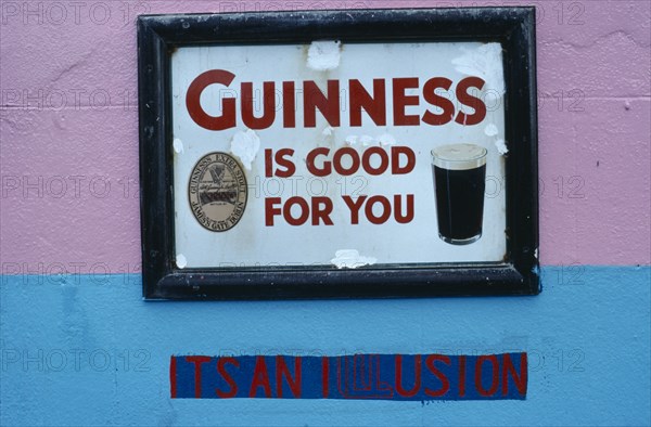 IRELAND, General, "Dan Foleys pub sign saying Guinness is Good for You, with the words Its an Illusion painted on the wall underneath"