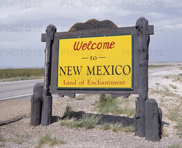 USA, New Mexico, General, Welcome To New Mexico sign in yellow with a wooden surround beside the road