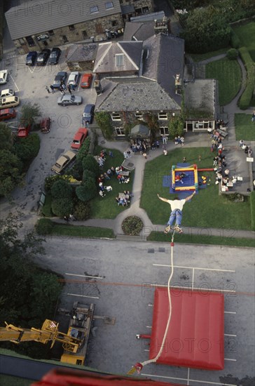 SPORT, Air, Bungee Jumping, "View from cage over falling bungee jumper, inflated safety mat and spectators.  "