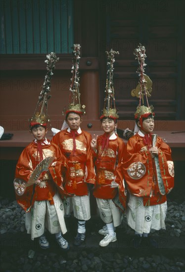 JAPAN, Honshu, Nikko, Four young boys in costume with elaborate head-dresses at the Autumn Festival in the temple grounds