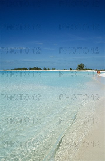 CUBA, Isla De Juventud, Cayo Largo, Playa Sirena with couple walking along the beach near the waters edge