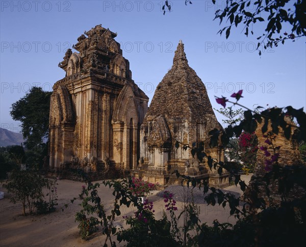 VIETNAM, South, Nha Trang, "Po Nagar Cham, two ornate stone towers framed by tree branches "