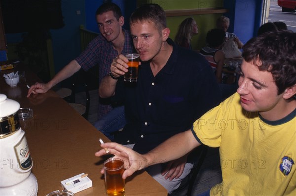 DRINK, Alcohol, Pub, Three young men smoking and drinking in bar.