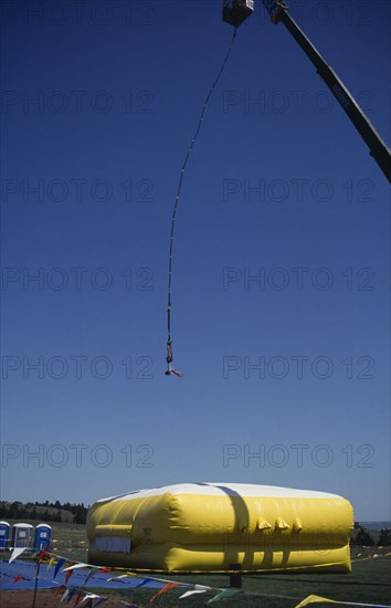 SPORT, Bungee Jumping, "Giant crane with jumper suspended over large inflatable, Rapid City, South Dakota."