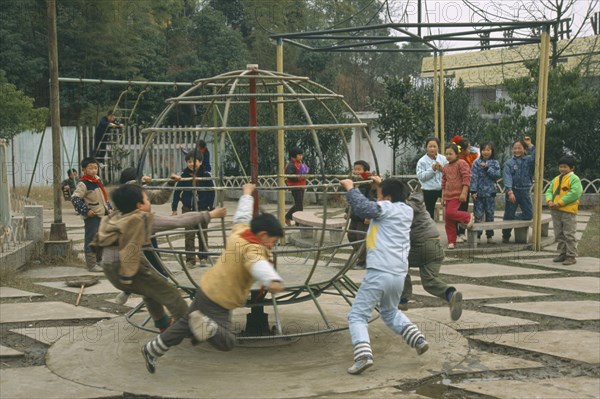 CHINA, Hunan, Huaihua, Children playing in park with climbing frames.