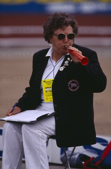 10039037 SPORT Athletics Javelin Female official blowing horn to warn that competitor is about to throw javelin.