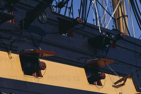 ENGLAND, Hampshire, Portsmouth, HMS Victory.  Detail of side of ship with cannons extending from openings.
