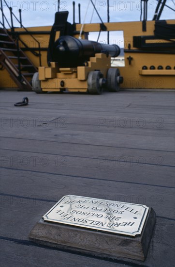 ENGLAND, Hampshire, Portsmouth, HMS Victory.  Detail of deck with cannon and brass plaque marking the spot where Admiral Nelson fell 21 October 1805.